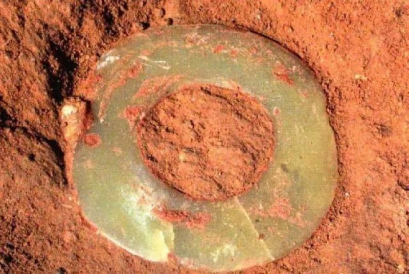 牛河梁N16M1：1-单圆玉璧-出土原生状态（未清理泥土）（下颌左侧）收藏于辽宁省文物考古研究院- 玉璧：一块圆玉里的五千年中华文明